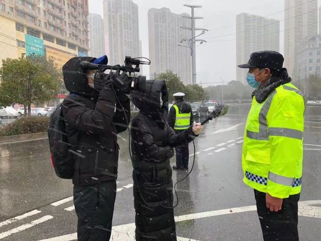 孝感市融媒體中心楊亞玲（風(fēng)雪中，采訪疫情期間重返一線的退休警察）_副本.jpg.jpg